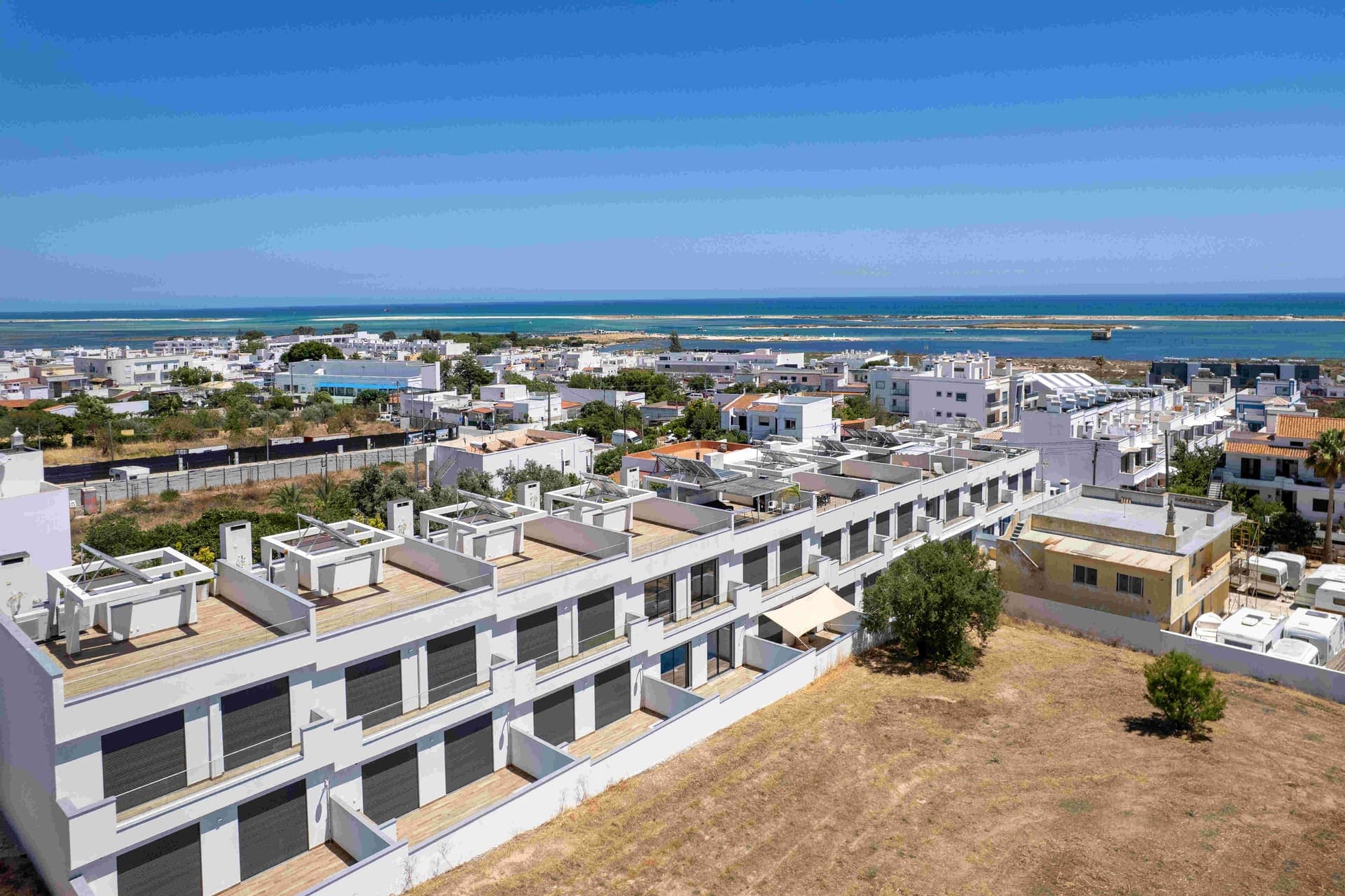 Aerial view of new homes by the Ria Formosa lagoon and the sea in the Algarve, Portugal