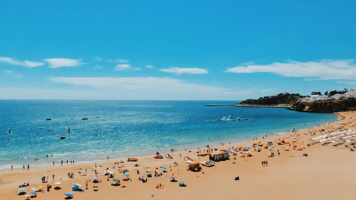 Belebter Strand an der Algarve-Küste im Frühling